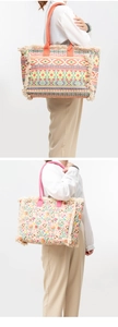 Detail of canvas tote bags with colorful patterns, bohemian tassels and sturdy straps