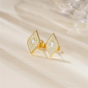 Macro shot of gold-plated rhombic stud earrings with pavé set white zircon stones