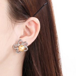 Détail de la boucle d'oreille fleur en acier inoxydable 18K avec perle portée par un modèle