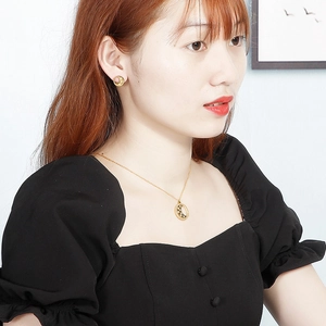 Dettaglio modella con collana a luna e stella dorata e orecchini a lobo coordinati nel set