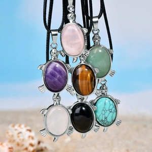 Collier pendentif tortue avec incrustations en pierre naturelle sur le sable