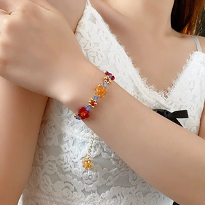 Gros plan d'un bracelet de fleurs en perles colorées avec des accents dorés