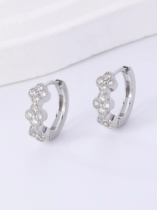 Detail of silver clover hoop earrings with sparkling cubic zirconia on a minimalist base