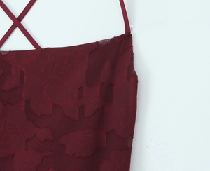 Detailaufnahme des dunkelroten Jacquard-Stoffs und der schmalen überkreuzten Träger