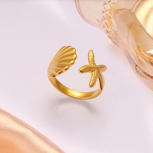 Macro shot of gold adjustable ring featuring textured starfish and shell ocean elements