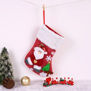 Détail d'une chaussette de Noël Père Noël rouge avec flocon en peluche 3D et panneau