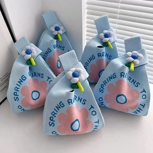 Blue knitted wedding favor gift bags with pink floral patterns and 3D flower accents