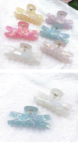 Close-up of laser acrylic hair claws with mica texture in blue and white colors
