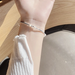 Close-up of 925 sterling silver baroque pearl elastic bracelet on a female wrist