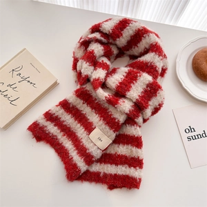 Detailed shot of red and white striped knit scarf with soft fringe and logo label
