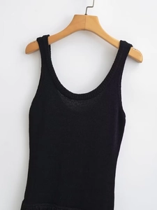 Gros plan sur la texture du tricot noir d'une robe moulante avec détails de couture