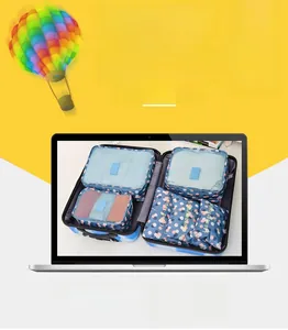 Detail of 6-piece blue floral travel organizer set inside a suitcase on yellow background