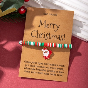 Close-up of Christmas wish bracelet with colorful clay beads and enamel Santa pendant