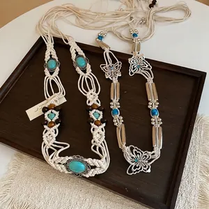Bohemian hand-woven waist chain with wooden beads and turquoise on a wooden tray