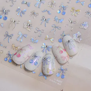 Detail of blue bow nail art stickers with crystal rhinestones on white manicured nails
