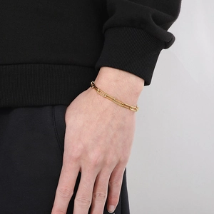 Close-up of a minimalist gold stainless steel square link chain bracelet on a wrist