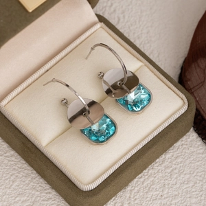 Elegant silver earrings with light blue square crystals in a green velvet jewelry box