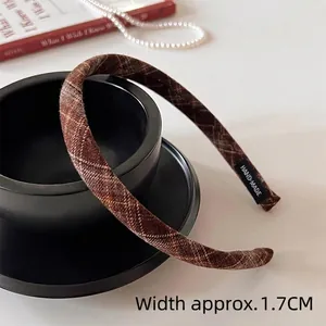 Detail view of brown plaid headband with 1.7cm width and a handmade quality label