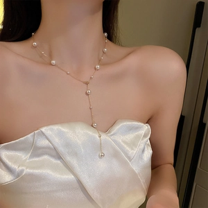 Elegant gold Y-shaped necklace with white pearls worn on neck for a stylish minimalist look