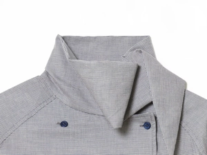 Close-up of gray plaid fabric neckline with dark blue buttons on woven shirt