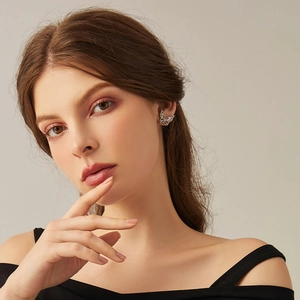 Boucles d'oreilles papillon élégantes en argent avec zircons portées par un modèle
