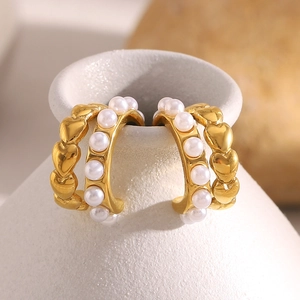 Orecchini vintage a cuore e perle placcati oro 18K esposti su un vaso di ceramica