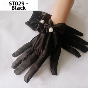 Detail of black satin bridal gloves featuring a 3D bow and pearl accent on the wrist