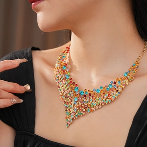 Close-up of vintage gold necklace with colorful crystals and rhinestones on model