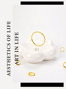 Macro view of gold and silver rings displayed on a white floral ceramic jewelry tray