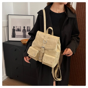 Vue détaillée d'un sac à dos beige en cuir vintage avec poches à boucles latérales