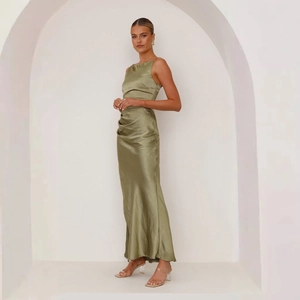 Detail of olive green satin dress featuring elegant waist pleats and glossy fabric texture