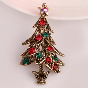 Close-up of vintage gold Christmas tree brooch with colorful rhinestones and textures