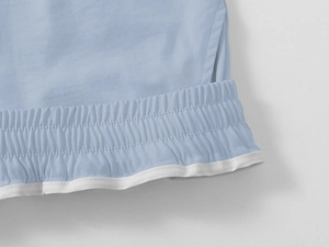 Detail of light blue cargo shorts featuring elastic waistband and white contrast piping