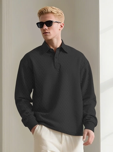 Detailed close-up of men's black long-sleeved polo shirt with geometric jacquard texture