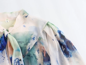 Λεπτομέρεια σιφόν μπλούζας tie-dye με κομψό δέσιμο στο λαιμό και πολύχρωμα σχέδια