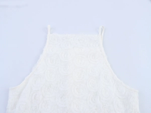 Macro detail of white camisole with 3D rose floral texture and delicate lace fabric
