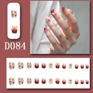 Detail of wine red and white gradient press-on nails with 3D bows and rose patterns
