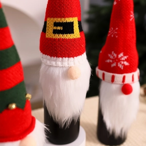 Close-up of knitted Christmas gnome wine bottle covers with plush beards and soft hats