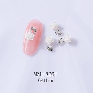 Detail view of 6x11mm white camellia nail charm with silver musical note and tiny rhinestones