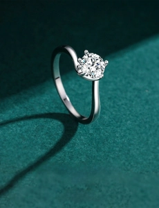Macro detail of a 925 sterling silver bypass ring with a four-prong set solitaire diamond