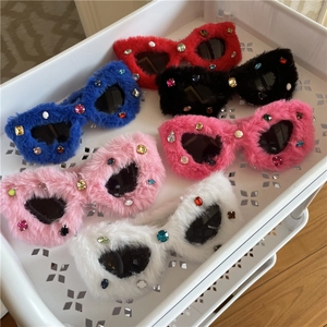 Close-up detail of plush cat-eye sunglasses with colorful rhinestones in various colors.