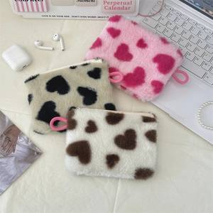 Detailed view of plush heart pattern coin purses in three colors with zippers and lanyards
