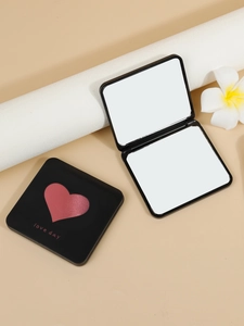 Close-up of black square compact mirror with red heart and foldable dual-sided glass
