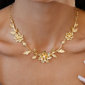 Macro detail of golden flower necklace with sparkling crystals on model's neck