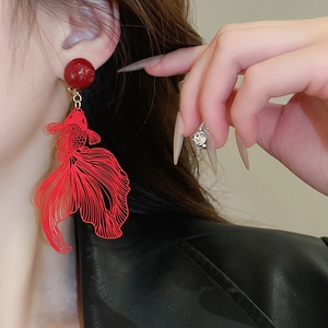 Close-up of red hollow goldfish earrings on ear showing intricate design and scale