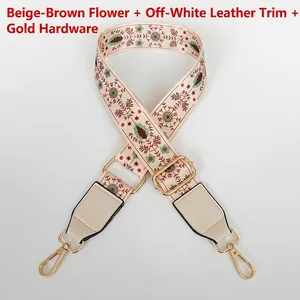 Detail of floral wide bag strap with beige leather ends and golden metal hardware