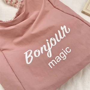 Detail of pink canvas tote featuring Bonjour Magic print and plush striped shoulder strap