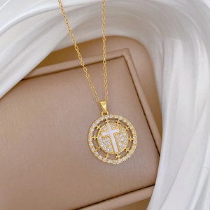 Macro detail of a gold cross pendant necklace with sparkling gems on silk