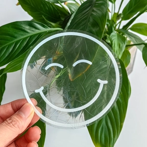 Detail of a transparent suncatcher glass sticker with a smiley face pattern and cracked texture