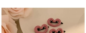 Detailed view of three sweet pink heart-shaped hair clips displayed on a white plate